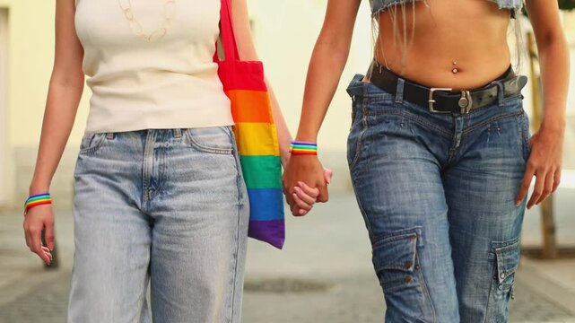 Lesbian couple holding hands walking on a sunny day