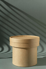 Brown round corrugated cardboard podium on green background with Light on wall. The concept mockup