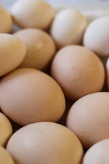 Close-up top view of fresh brown eggs in natural light. Organic farm produce, simple composition, soft focus. Natural texture and neutral tones for food and market concepts. High quality photo