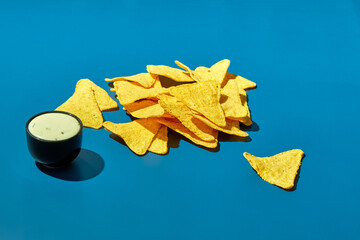 Naklejka premium Nachos corn chips with ranch sauce on a colored background. Mexican cuisine