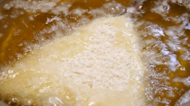 和食のアジフライ。パン粉をまとった鯵を油であげる動画。