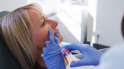 Mature Woman Sitting In Chair Being Give Anti Ageing Injection By Female Doctor