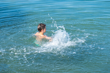 young boy play in open water, ocean on sunny summer day, Water activities, prevent drowning, aquatic adventures foster curiosity and love for environment in kids