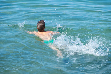 child swims in in open water, sea, confronting fear deep water and potential dangers drowning,...