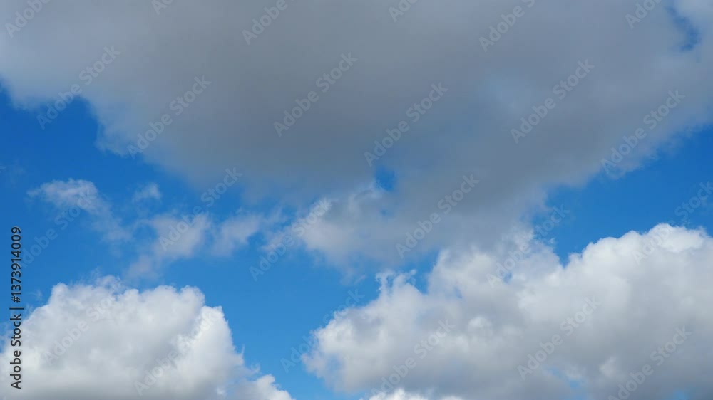 Poster Observe the mesmerizing dance of fluffy clouds as they glide through the sky in real time, showcasing their ethereal forms and ever-changing patterns under the influence of the wind