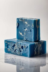 Fototapeta premium Unique handmade blue soap bars with marbled patterns displayed on a reflective surface