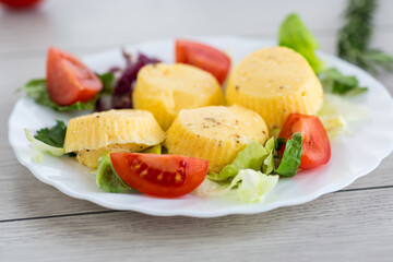 Round omelette with tomatoes and fresh lettuce on a served table