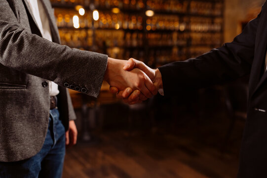 Business deal handshake in an elegant bar setting
