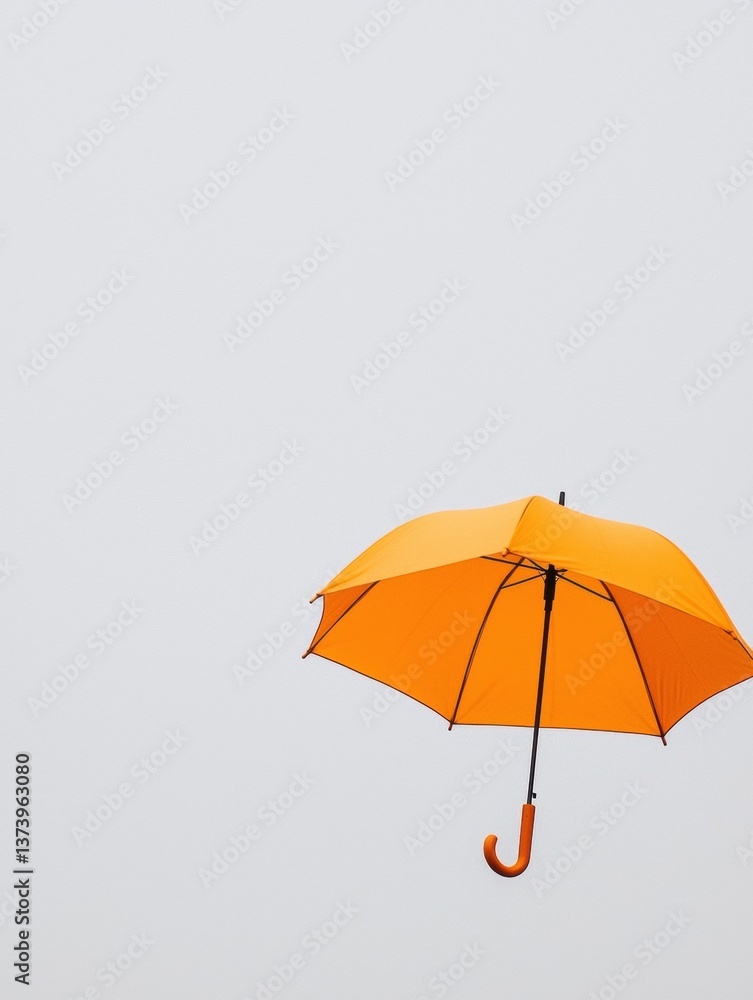 Poster the image is of an orange umbrella with a black handle. the umbrella is open and appears to be float