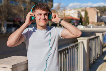 Young man enjoying music on headphones outdoors