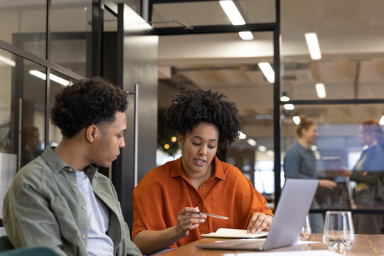 Business manager training new employee in an office