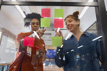 Two women collaborating using colorful sticky notes