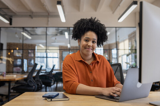 Smiling Woman Working on Computer in Office