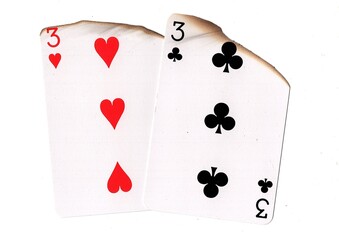 A pair of partially burnt playing cards of the same value on a white background.