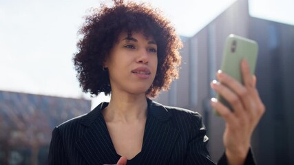 Woman nodding and saying goodbye on video call outside