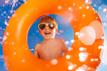 Happy child playing in waterpark. Kid having fun on summer vacation
