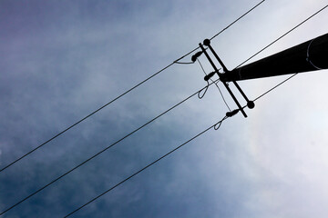 Power lines against a cloudy sky. Industrial infrastructure with a minimalist and abstract composition