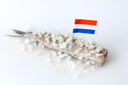 Dutch herring with onion on the white board, Netherlands flag