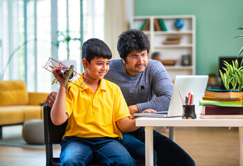 Indian schoolboy and father exploring aeronautical engineering concepts together using a laptop