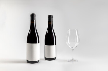 Mockup of classic bottle of red wine garnacha, front and back view, with glass of wine, on white background with copyspace, 750 ml, real photo