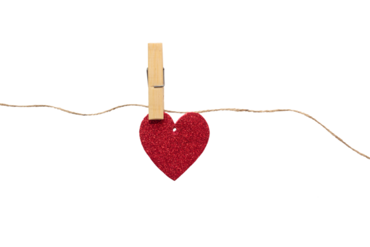 Paper heart with glitter hanging on a rope with a clothespin. Heart isolated on white background