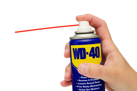 WD-40 Lubricant in a spray can held against a white background. December 05, 2024 United Kingdom
