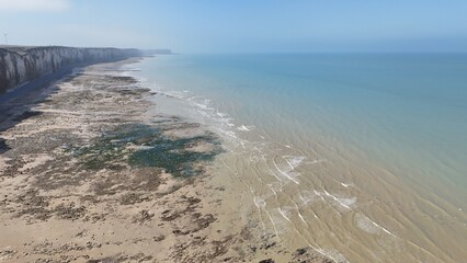 Drone picture of the English Channel from the cliffs of Normandy stretching up to the horizon, near Veules-les-roses, Normandy, France, during low tide on a beautiful spring day.