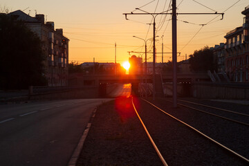 Cityscape with bright orange-red sun in the morning at sunrise in Krasnoyarsk, Russia. Empty city street in the early morning
