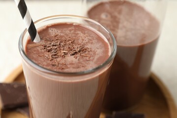 Tasty chocolate milk with shavings on white table, closeup
