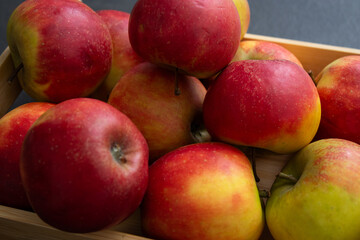Close up of fresh small organic red apples in a wooden crate