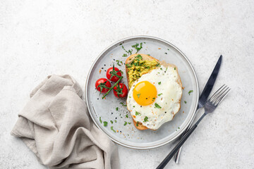 Toast with mashed avocado and fried egg garnished with crushed pepper mix. Top view