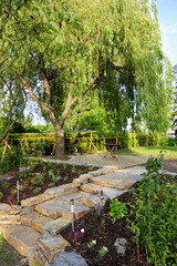 Idyllischer Naturgarten mit Steinmauer und Holzterrasse
