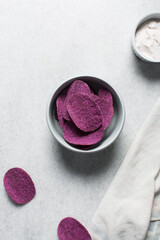 Overhead view of purple sweet potato chips, purple potato crisps on white background