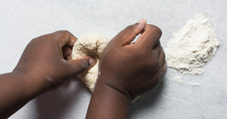 Overhead view of baozi dough being kneaded on a white countertop, top view of mantou dough being mixed, process of making bao buns