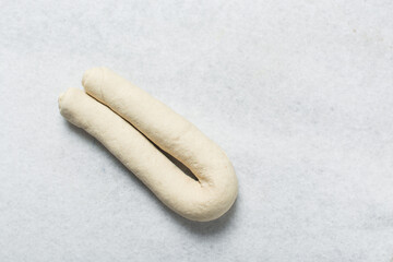 Overhead view of baozi dough being shaped on a white granite countertop, top view of mantou dough being divided on granite countertop, process of making bao buns