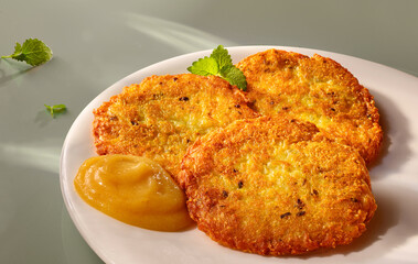 Kartoffelpuffer mit Apfelmus auf weilssem Teller, Reibekuchen, Kartoffeln, isoliert, 
