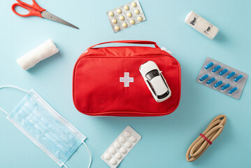 Red-themed first aid kit with various medical supplies and medications laid out on a blue surface