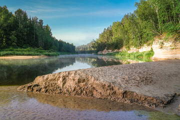 Early summer morning by the river with sand outcrops and dense forests