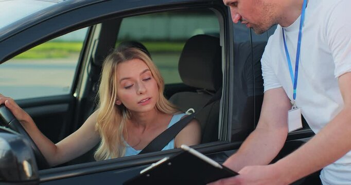 Man driving school instructor with clipboard and woman driver in car. Education, examination and people concept.