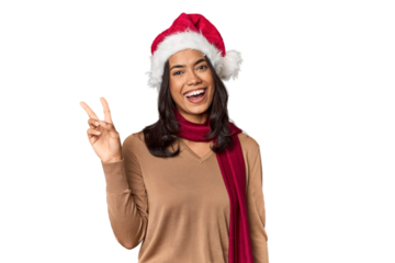 Filipino in Christmas attire and Santa hat joyful and carefree showing a peace symbol with fingers.