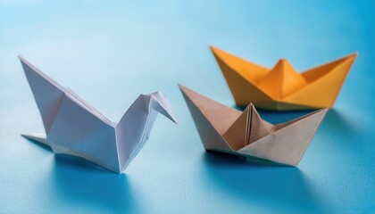 Colorful origami boats and bird on a blue background, symbolizing creativity and art.