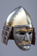 Historical metallic combat helmet with integrated face mask. Pointed steel helmet featuring a...