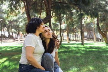 Mother and daughter enjoying a peaceful moment in the park during a sunny afternoon