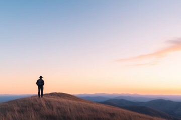 Obraz premium silhouetted ecologist stands on hill at sunset surveying vast landscape