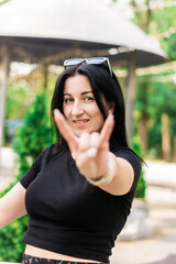Brunette girl in a black t-shirt and black pants in the park
