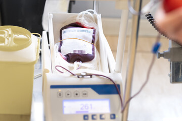 A blood transfusion bag is filled with the blood of a volunteer. It is on a stirring balance and a display shows the status of the donation