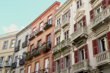 Vibrant architecture showcases detailed balconies and shutters on buildings in a bustling city