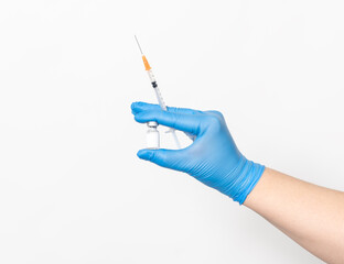 Ärztin hält eine Impfdose mit einem Impfstoff und einer Einwegspritze in der Hand