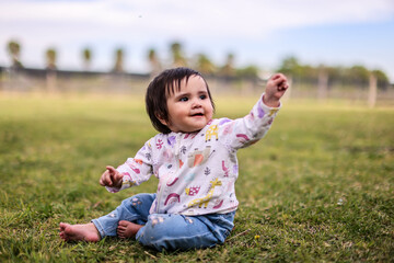 Outdoor portrait of a cute baby girl playing in garden