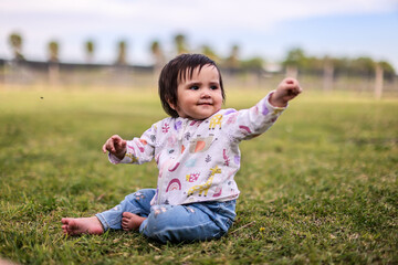 Outdoor portrait of a cute baby girl playing in garden